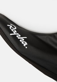 Gorra de ciclismo negra con un acabado mate suave, que presenta un prominente logo blanco "Rapha" en el lateral, diseño curvado con bordes suaves.