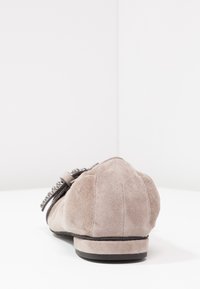 Scarpa piatta in suede grigio con punta arrotondata e suola piatta. Presenta una fascia decorativa con dettagli metallici vicino al tallone.