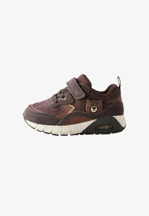 Dziecięce sneakersy w brązowych odcieniach, z cholewką z siatki i zamszu, rzepem, naszywką w kształcie misia oraz białą podeszwą w kropki z poduszką powietrzną.