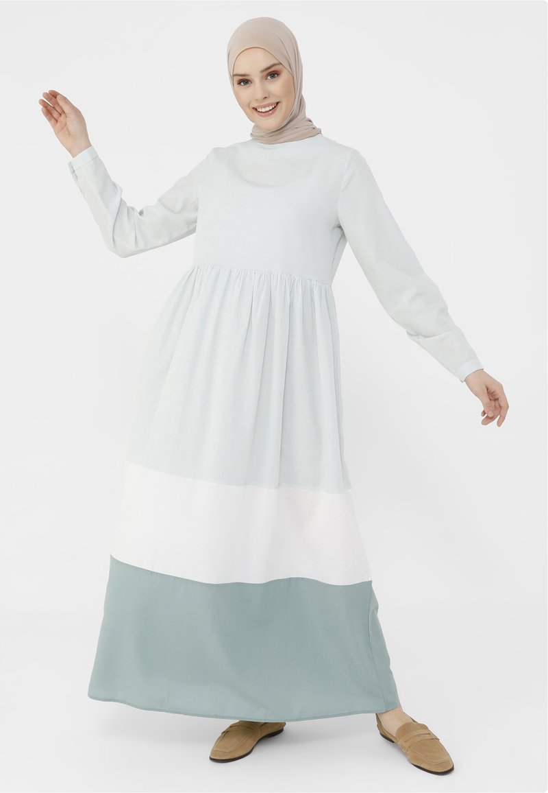 Vestido de manga larga en verde menta, paneles blancos y de azul suave. Hecho de tela ligera con una cintura fruncida y un escote redondo modesto.