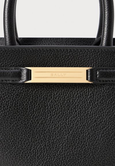Sort læderhåndtaske med en struktureret overflade, elegant design, korte håndtag og en plade i guldtonet med "BALLY" præget på.