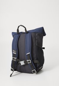 Marinblå ryggsäck gjord av slitstarkt material, med en rulltoppsdesign, justerbara remmar, sidoficka i mesh och ett framknäppningsstängning.