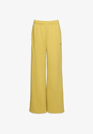 Żółte szerokie spodnie dresowe wykonane z miękkiego materiału, z elastycznym paskiem w talii i małym logo na dolnej stronie.