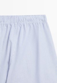 Tessuto a righe azzurro chiaro e bianco con una vita elastica arricciata. La texture è liscia, con sottili linee verticali come motivo.