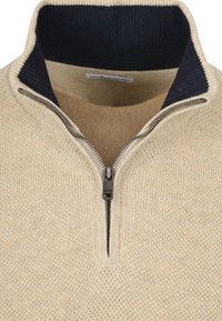 Beiger gestrickter Pullover mit hohem marineblauen Kragen. Verfügt über einen Viertel-Reißverschluss und ein strukturiertes Material, das ein warmes und lässiges Design schafft.