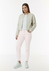 Jasnoszary pikowany bomber, krótki, zestawiony z jasnoróżowymi rurkami i jasnoniebieskimi trampkami. Prosty design, bez wzorów.