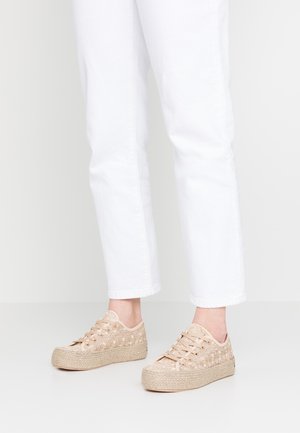 Beżowe sneakersy na sznurówki z plecionymi juty, z fakturowanym wierzchem w kwiatowe wzory, połączone z białymi spodami jeansowymi 7/8.