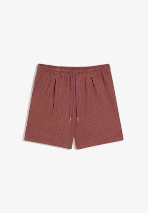 Shorts en maille côtelée de couleur rouille avec taille élastique et cordon central, présentant des plis frontaux subtils et une coupe décontractée.