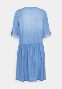 Denimklänning med rund halsringning, korta upprullade ärmar och en samlad midja som faller till en utsvängd nederdel. Ljusblå färg, mjuk textur.