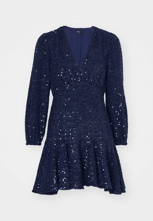 Vestido azul marino con lentejuelas, escote en V profundo, mangas largas abullonadas y dobladillo acampanado. Cuenta con una tela texturizada con detalles brillantes en toda su superficie.