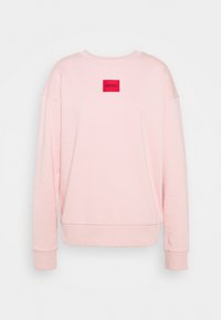Sudadera rosa con un escote escalonado, mangas largas y un parche rectangular rojo con la etiqueta "HUGO" en la parte delantera. Textura suave.