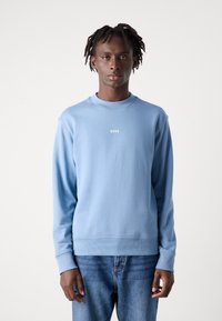 Φωτεινό μπλε φούτερ με στρογγυλή λαιμόκοψη, ραμμένες μανσέτες και στρίφωμα. Διαθέτει ένα μικρό λευκό λογότυπο "BOSS" στο στήθος. Συνδυάζεται με τζιν παντελόνι.