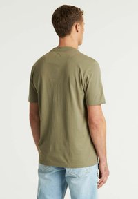 Alyvinės spalvos medvilninė marškinė su trumpomis rankovėmis ir apvaliu kaklu. Yra subtilus siuvinėjimo detalė kakle. Derinama su šviesiai mėlynu džinsiniu audiniu.