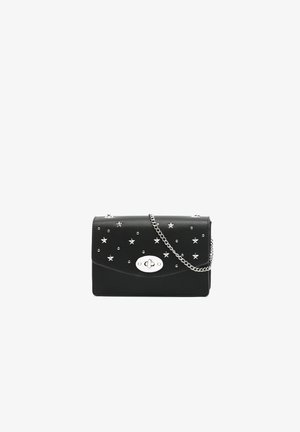 Schwarze Lederhandtasche mit Stern- und Nietenverzierungen, ausgestattet mit einem silbernen Kettenriemen und einem silbernen ovalen Verschluss auf der Vorderseite.