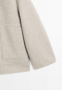 Hellgrauer Wollmischmantel mit strukturiertem Design, der eine einzelne Tasche und saubere Nähte entlang der Kanten aufweist.