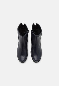Botas de cuero azul marino hasta el tobillo con un acabado suave, que cuentan con un zip lateral y una puntera redondeada, y un interior acolchado para mayor comodidad.