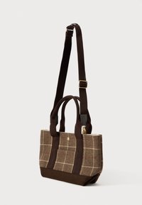 Καφέ καρό τσάντα ώμου με ρυθμιζόμενο σκούρο καφέ λουρί και λαβές, που διαθέτει μια μικρή μπροστινή τσέπη και χρυσές λεπτομέρειες.