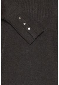 Manche de pull côtelée foncée avec un poignet boutonné, ornée de trois boutons argentés brillants alignés verticalement sur le poignet.