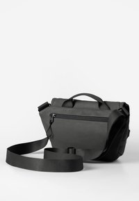 Borsa a tracolla grigio scuro con manico superiore, tracolla regolabile, tasca frontale con zip e superficie testurizzata. Design semplice e rettangolare.