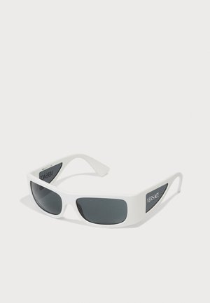 Óculos de sol oversized brancos com lentes escuras, formato retangular arredondado, logótipo Versace na lateral e armação de plástico suave.