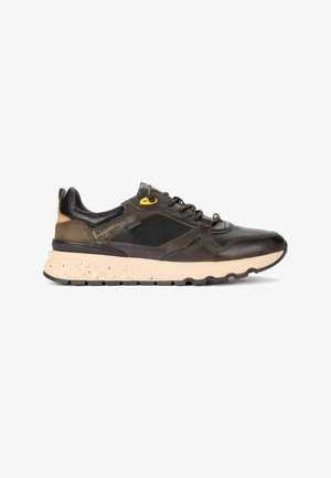 Sneaker marrone scuro e nero con suola beige, pannello laterale in mesh, chiusura frontale con lacci e piccoli dettagli gialli e beige su sfondo bianco.