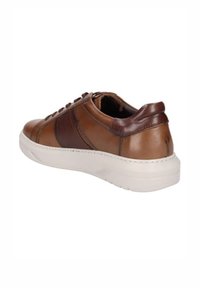 Zapatilla de cuero marrón con un diseño texturizado, suela de goma blanca y cierre con cordones. Presenta un panel lateral liso y perforado.