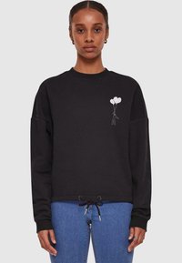 Black sweatshirt featuring a drawstring hem, oversized fit, and a white graphic of a person holding two balloons on the left chest.