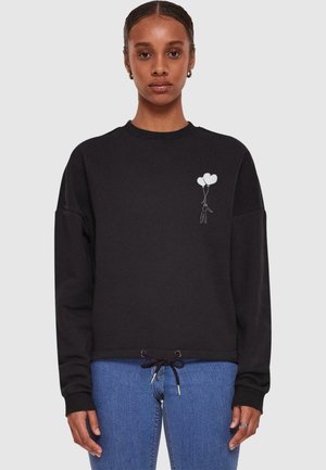 Black sweatshirt featuring a drawstring hem, oversized fit, and a white graphic of a person holding two balloons on the left chest.