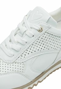Sneaker bianca in pelle con dettagli perforati, lacci piatti, occhielli in metallo e suola in gomma beige testurizzata. Logo a forma di cuore discreto sulla linguetta.