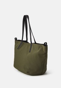 Olivgrüne Stofftasche mit schwarzen Ledergriffen, mit einer weichen Textur und einem minimalistischen Design. Beinhaltet zwei Obergriffe zum Tragen.