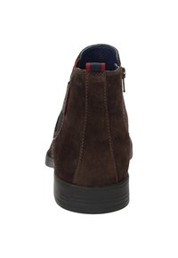 Braune Wildleder-Ankleboots mit einer strukturierten Oberfläche, schwarzer Gummisohle und kontrastierenden blauen und roten Akzenten am Kragen und Reißverschluss.