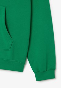 Sudadera de algodón verde con un bolsillo frontal, puños y dobladillo de canalé. Textura suave con un acabado liso; sin patrones ni adornos visibles.