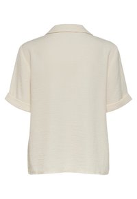 Blouse à manches courtes de couleur crème, confectionnée dans un tissu léger. Elle présente un col et des poignets retroussés avec une surface texturée.