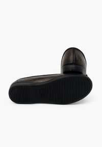Scarpe in pelle nera con punta arrotondata e suola in gomma testurizzata. Presentano una parte superiore liscia con dettagli di cucitura minimi.