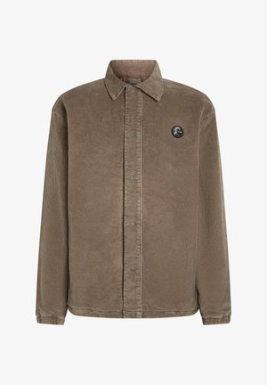 Veste en velours côtelé marron avec un devant à boutons, un col pointu, des manches longues, et un patch logo circulaire sur la poitrine gauche.