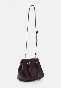 Czarna torebka bordowa w sztucznej skórze krokodyla o strukturalnym kształcie, z górnymi uchwytami i odczepianym paskiem na ramię. Złote akcenty metalowe.