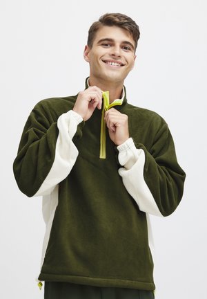 Green and white fleece pullover with a half-zip collar, elastic cuffs, and contrast zipper. Soft texture, relaxed fit.