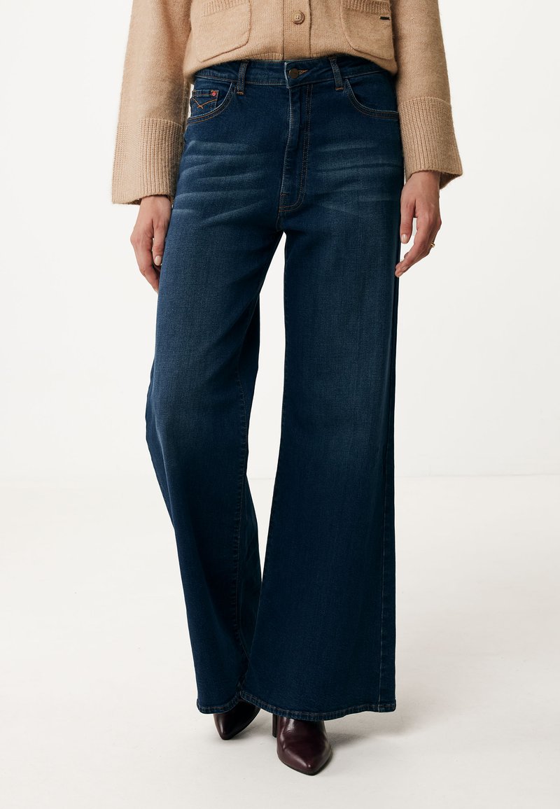 Vidbenade jeans i mörk indigo. Har subtil blekning, femficksdesign och klassisk knappstängning i metall. Slät textur.