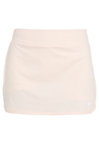 Falda de tenis Nike de color rosa claro con un material suave y elástico, cinturilla elástica y un pequeño logo blanco en la esquina inferior derecha.