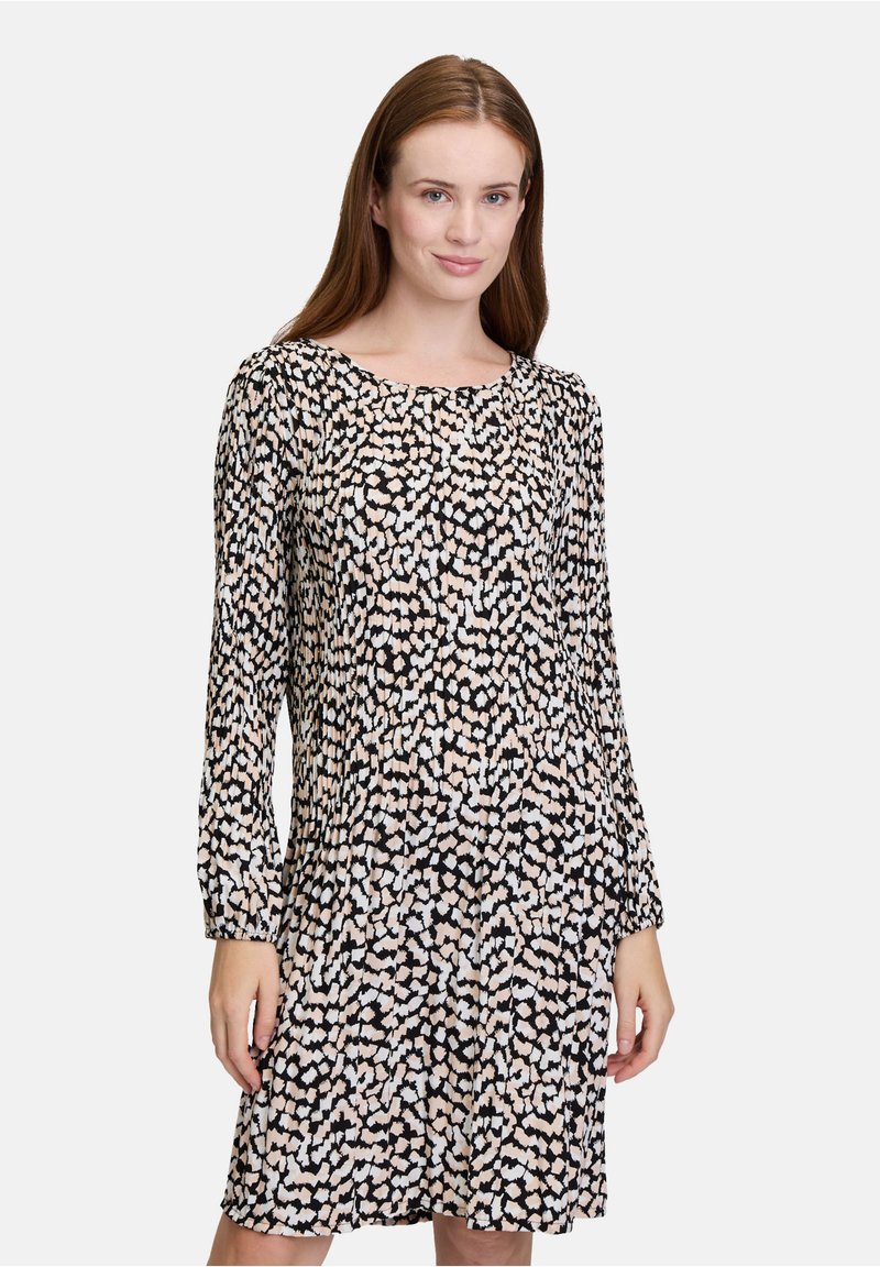 Langärmliges Kleid in Schwarz mit einem verstreuten weißen und pfirsichfarbenen Muster, ausgestattet mit einem runden Halsausschnitt und strukturiertem Stoff.