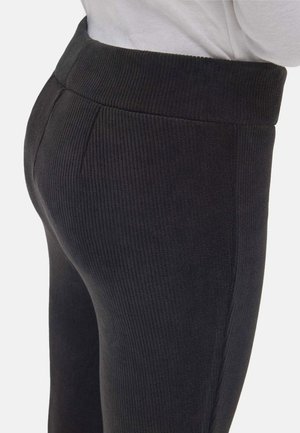 Leggings negras acanaladas con una pretina ancha y costuras laterales, que cuentan con una textura suave y un diseño ajustado, aptas para uso casual.