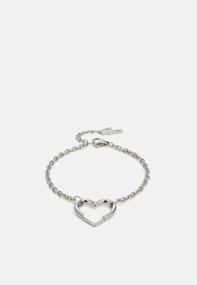 Sølv armbånd med kjededesign og et hjerteformet anheng. Hjertet er åpent, noe som fremhever den strømlinjeformede, moderne formen.