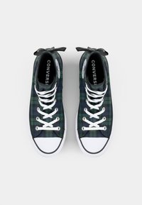 Wysokie sneakersy w zielono-granatowym wzorze w kratę, z białymi sznurówkami i gumową podeszwą. Posiadają czarne wnętrze oraz widoczne logo marki wewnątrz.