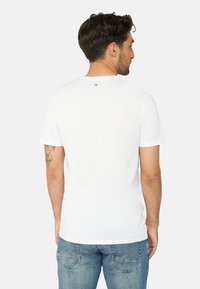 Hvid kortærmet t-shirt med rund hals, lavet af bomuld. Har et lille logo på den øverste ryg og en afslappet pasform.