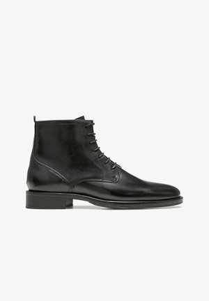 Bottines en cuir noir avec une finition lisse, bout rond, design à lacets et un petit talon empilé. Présente des accents de couture subtils.