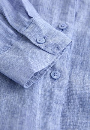 Hele sinine linane särk, millel on tekstuuriga materjal, nööpkinnitus ning üks nupp mansetil, viimistletud siledalt.