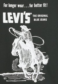 Czarny t-shirt z białą grafiką przedstawiającą kowboja na koniu, chwytającego lasso. Tekst brzmi „LEVI'S® ORYGINALNE NIEBIESKIE DŻINSY.” Prosty, wyrazisty design.