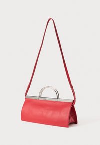 Rote Leder-Handtasche mit langem Riemen und silbernen halbkreisförmigen Obergriffen, strukturierte rechteckige Form, vor weißem Hintergrund.