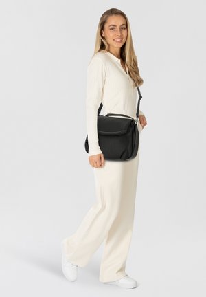Schwarze Leder-Crossbody-Umhängetasche mit strukturiertem Design, Klappenverschluss, silbernem Zubehör und verstellbarem Tragegurt. Glatte Oberfläche.