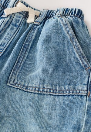 Lyseblå denimshorts med elastisk talje og en cremefarvet snor, med sidelommer og synlige syningsdetaljer.